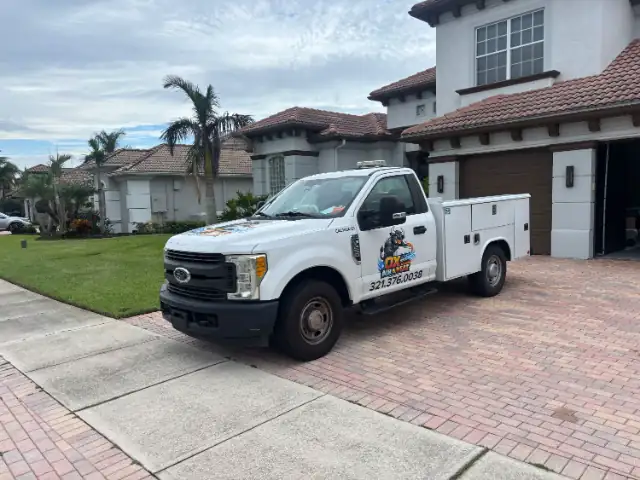 The Ox Air & Heat Ford F-250 utility service truck parked in a paver driveway, with the bull logo and phone number on the door.